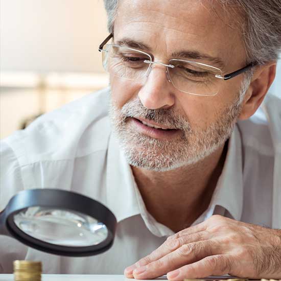 Mann mit vergrößernder Sehhilfe.